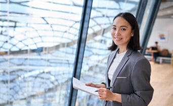 Smiling young Asian business woman manager standing in office