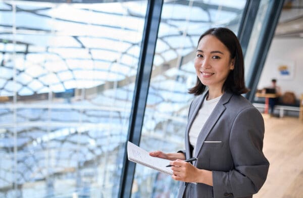 Smiling young Asian business woman manager standing in office