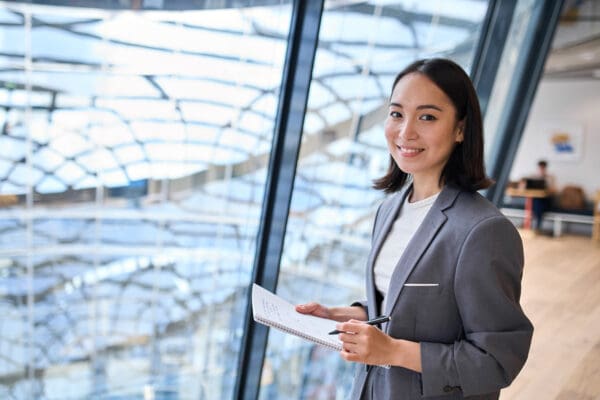 Smiling young Asian business woman manager standing in office